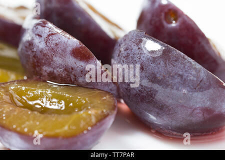 Gros plan macro de tranche de délicieux jus de prune mûre et de petits fruits congelés frais. concept Banque D'Images