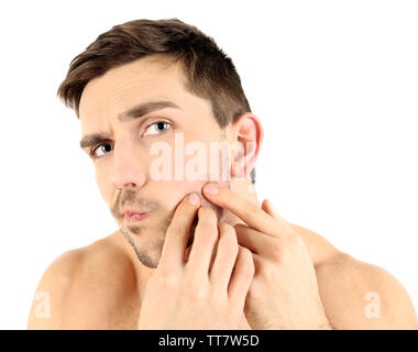 Beau jeune homme serrant pimple isolated on white Banque D'Images
