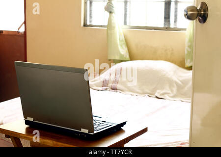 Photo d'un ordinateur portable sur une table en bois à l'intérieur d'une chambre Banque D'Images