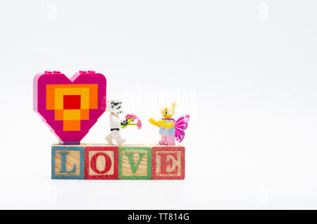 Storm Trooper lego fleur donnant de butterfly girl et offrant pièce de forme de coeur. Figurines LEGO sont fabriquées par le Lego Banque D'Images