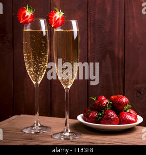 Deux verres de champagne classique avec des fraises de bois sur un fond sombre. Accueil soirée romantique Banque D'Images