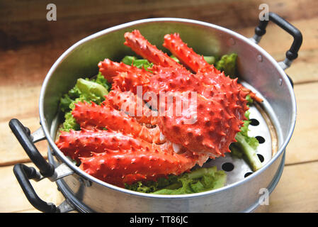 Le Crabe royal d'Alaska cuiseur vapeur cuit vapeur pot alimentaire sur les fruits de mer et légumes laitue sur fond de bois / crabe rouge Hokkaido Banque D'Images