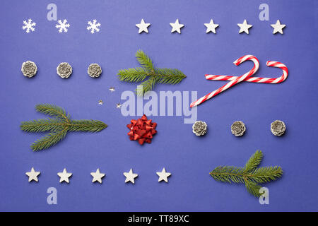 Composition de Noël avec du sucre de cannes, de stars, de cônes et de branches de sapin sur fond bleu foncé Banque D'Images