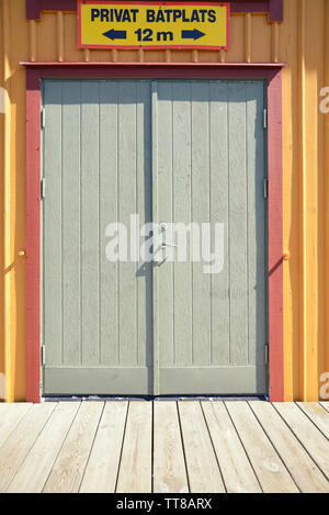 Vieille porte de garage en bois gris avec interdiction suédoise sign Banque D'Images
