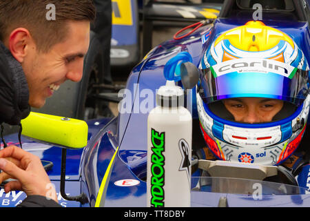 Zane Maloney, pilote automobile barbadienne attend dans sa voiture. La formule 4 paddock, avant de pouvoir bénéficier à Brands Hatch Banque D'Images