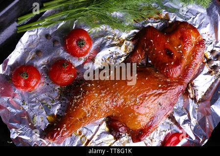 Cuisse de poulet fumé avec des tomates cerises sur l'aluminium close up Banque D'Images