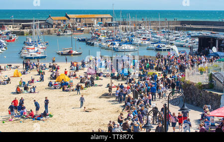 Lyme Regis, dans le Dorset, UK. 15 juin 2019. Météo France : la foule des musiciens et visiteurs affluent à la plage Profitez d'un après-midi de la musique comme les guitares annuel sur l'événement sur la plage est en cours sur la plage de Lyme Regis sur un glorieux après-midi de soleil et un ciel bleu lumineux. La foule est la star du spectacle comme guitaristes de tous âges et de se réunir sur la plage effectuer ensemble en tant que 'Britain's plus gros groupe'. Les gens apprécient l'atmosphère avant d'effectuer le festival cette année, le morceau choisi "sur la plage". Credit : Celia McMahon/Alamy Live News. Banque D'Images