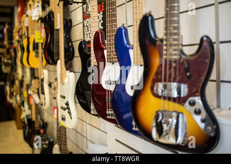 Guitares Basses accroché au mur du magasin de musique vente Banque D'Images