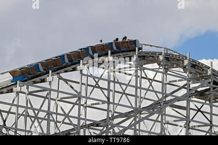 Montagnes russes dans un parc d'attractions sur fond de ciel nuageux Banque D'Images