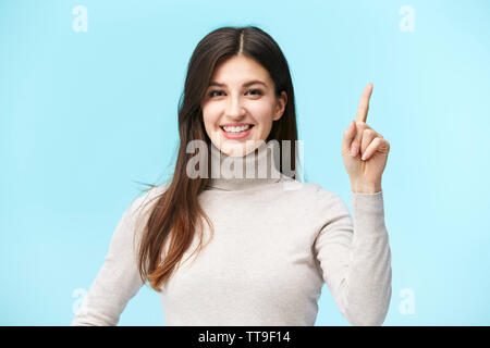 Belle jeune femme caucasienne montrant une première marque, smiling, isolé sur fond bleu Banque D'Images