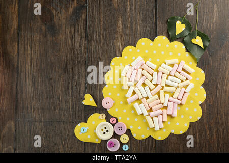 Marshmallow disposés en forme de coeur avec des boutons sur la table close up Banque D'Images