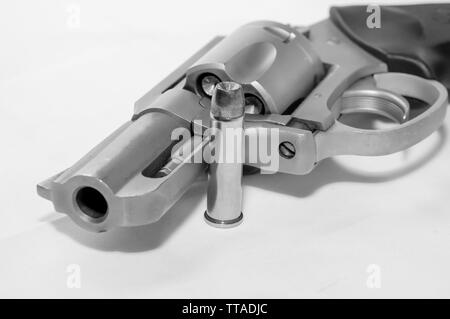 Un revolver chargé en acier inoxydable 357 avec une balle à pointe creuse à côté tourné en noir et blanc Banque D'Images
