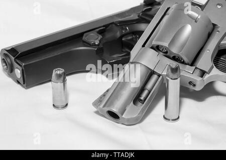 Deux armes de poing, un pistolet de calibre 40 et un revolver Magnum 357 avec une balle pour chaque tourné en noir et blanc Banque D'Images