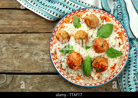 Les boulettes de viande en sauce tomate avec du riz bouilli et de lentilles, cuillère en bois sur fond de bois Banque D'Images