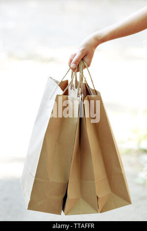 La main féminine holding shopping bags outdoors Banque D'Images