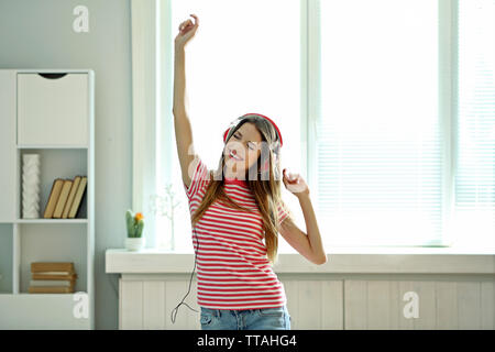 Woman listening music casque en arrière-plan on windowsill Banque D'Images