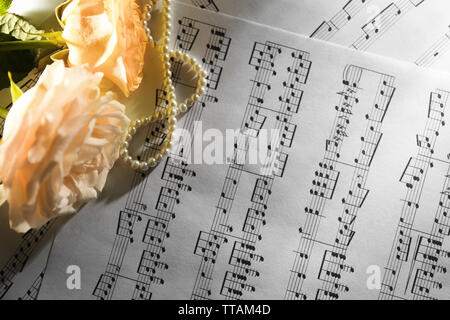 Belles roses avec des perles sur les feuilles de musique historique Banque D'Images