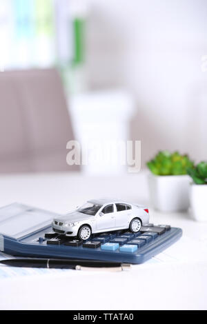 Petite voiture, documents et calculatrice sur la table. Concept d'assurance auto Banque D'Images