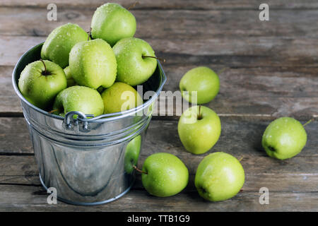 Ripe green apple en metal godet sur table en bois close up Banque D'Images