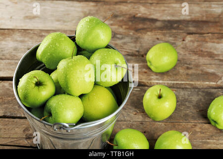 Ripe green apple en metal godet sur table en bois close up Banque D'Images