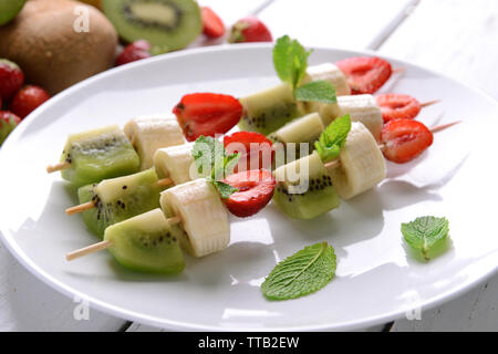 Les fruits sur les brochettes dans la plaque sur la table, gros plan Banque D'Images