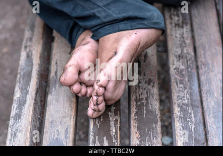 Homme sans domicile sur banc, close-up de jambes sale mendiant Banque D'Images