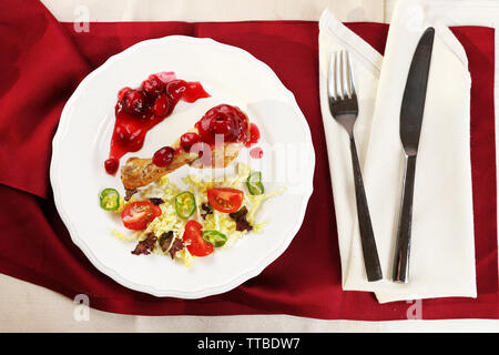 Plat de poulet au four salade de légumes et de jambe en plaque blanche sur table avec des serviettes, vue du dessus Banque D'Images