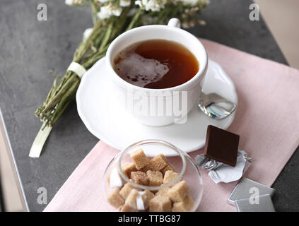 Tasse de café aromatisé avec du chocolat sur la table avec des nappes, gros plan Banque D'Images