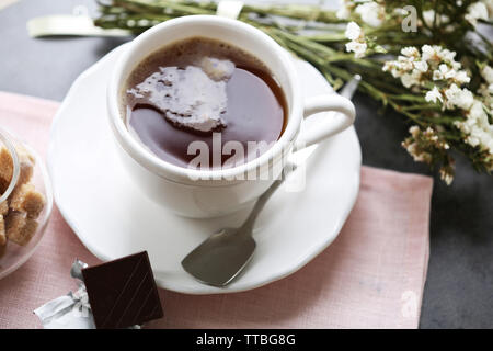 Tasse de café aromatisé avec du chocolat sur la table avec des nappes, gros plan Banque D'Images