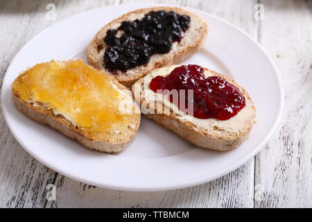 Des toasts avec du beurre et confitures différentes sur la table close up Banque D'Images