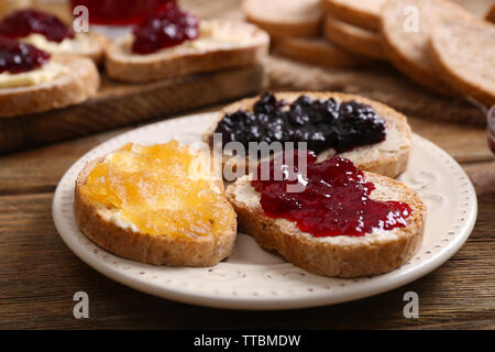 Des toasts avec du beurre et confitures différentes sur la table close up Banque D'Images