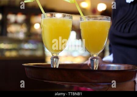 Verres de cocktails jaune sur le bac en hôtellerie en mains cafe Banque D'Images