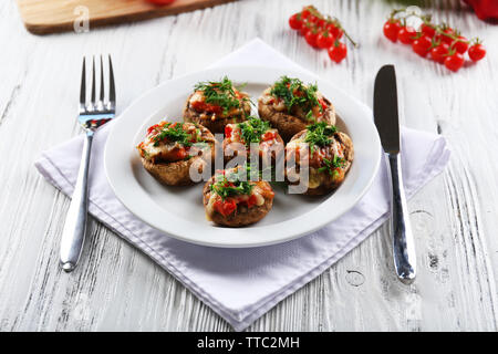 Table servi avec les champignons farcis sur fond de bois blanc Banque D'Images