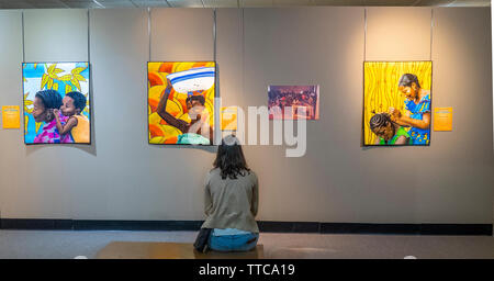 Femme assise et l'étude d'une série de quilt par artiste africain Printemps Quilt Show 2019 Paducah Kentucky USA Banque D'Images