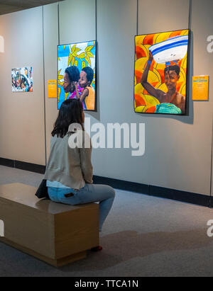 Femme assise et l'étude d'une série de quilt par artiste africain Printemps Quilt Show 2019 Paducah Kentucky USA Banque D'Images