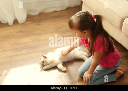 Cute little girl Playing with chaton à la maison Banque D'Images