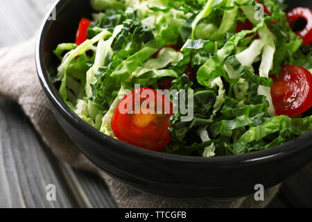 Chou salade de tomates et servi dans un bol sur la table en bois Banque D'Images