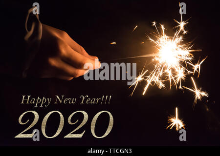 2020 bonne année carte d'une main tenant un sparkler Banque D'Images