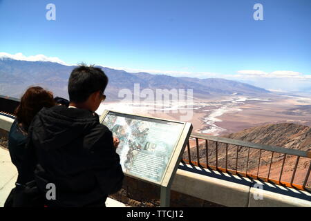 Les touristes l'étude d'un plan de la Death Valley à Zabriskie Point, California, USA Banque D'Images