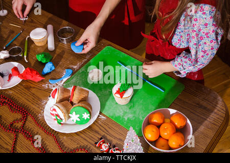 Le menu du dîner de Noël - idée de dessert au chocolat et à la menthe délicieux cupcakes avec fromage café crème et sucre aspersion. Mère et fille pre Banque D'Images