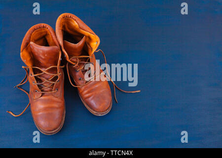 Old Red high shoes sale sur fond bleu. Old school vintage porté des bottes avec lacets en cuir. Banque D'Images