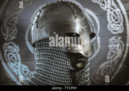 Triskel, Vikings, Casque viking avec chaîne mail sur un bouclier rouge avec Golden Sun de formes, des armes pour la guerre Banque D'Images