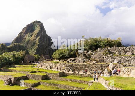 Le Machu Picchu au Pérou - Touristes marcher autour de la citadelle de Machu Picchu, avec vue sur la montagne Huayna Picchu en arrière-plan, le Pérou. Banque D'Images