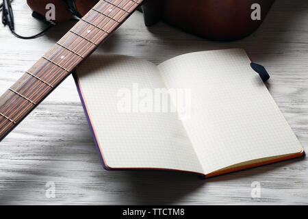 Guitare acoustique, écouteurs, microphone et l'ordinateur portable ouvert sur fond de bois, Close up Banque D'Images