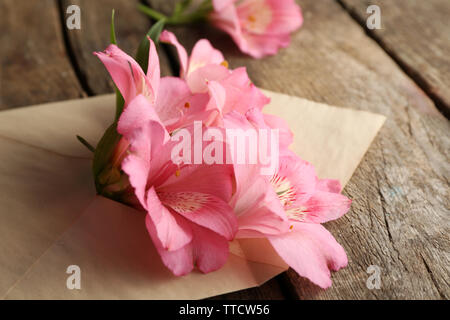 L'alstroemeria rose dans une enveloppe sur fond de bois Banque D'Images