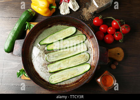 Des ingrédients frais et des tranches de courgettes frites pour la préparation des rouleaux de courgettes sur fond de bois Banque D'Images