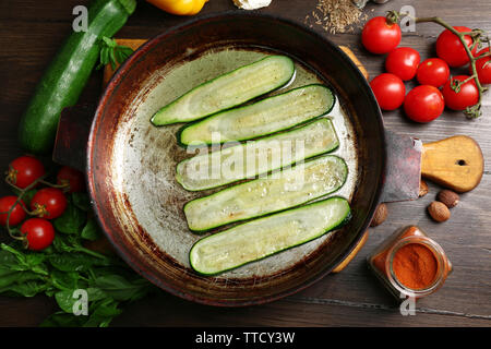 Des ingrédients frais et des tranches de courgettes frites pour la préparation des rouleaux de courgettes sur fond de bois Banque D'Images