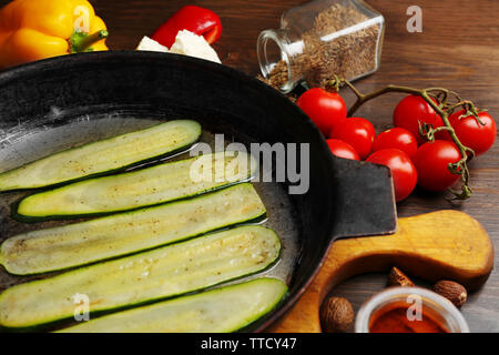 Des ingrédients frais et des tranches de courgettes frites pour la préparation des rouleaux de courgettes sur fond de bois Banque D'Images