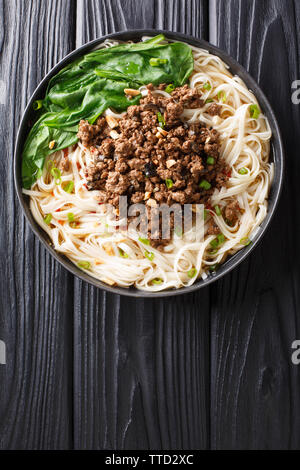 Recette pour dan dan des nouilles avec de la viande hachée et les verts libre dans une assiette sur la table. Haut Vertical Vue de dessus Banque D'Images