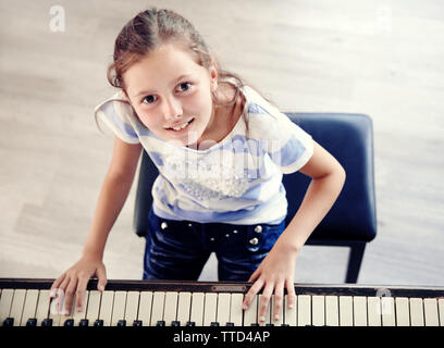 Cute little girl musicien joue du piano, voir Banque D'Images